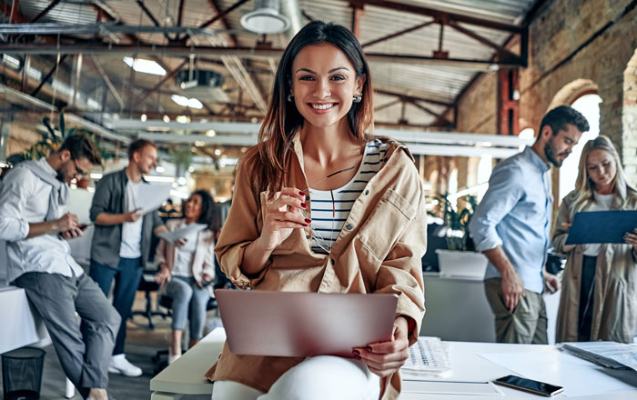 a happy woman holding a laptop